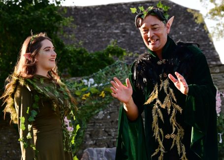 Two people in nature-themed costumes engage in a lively conversation.